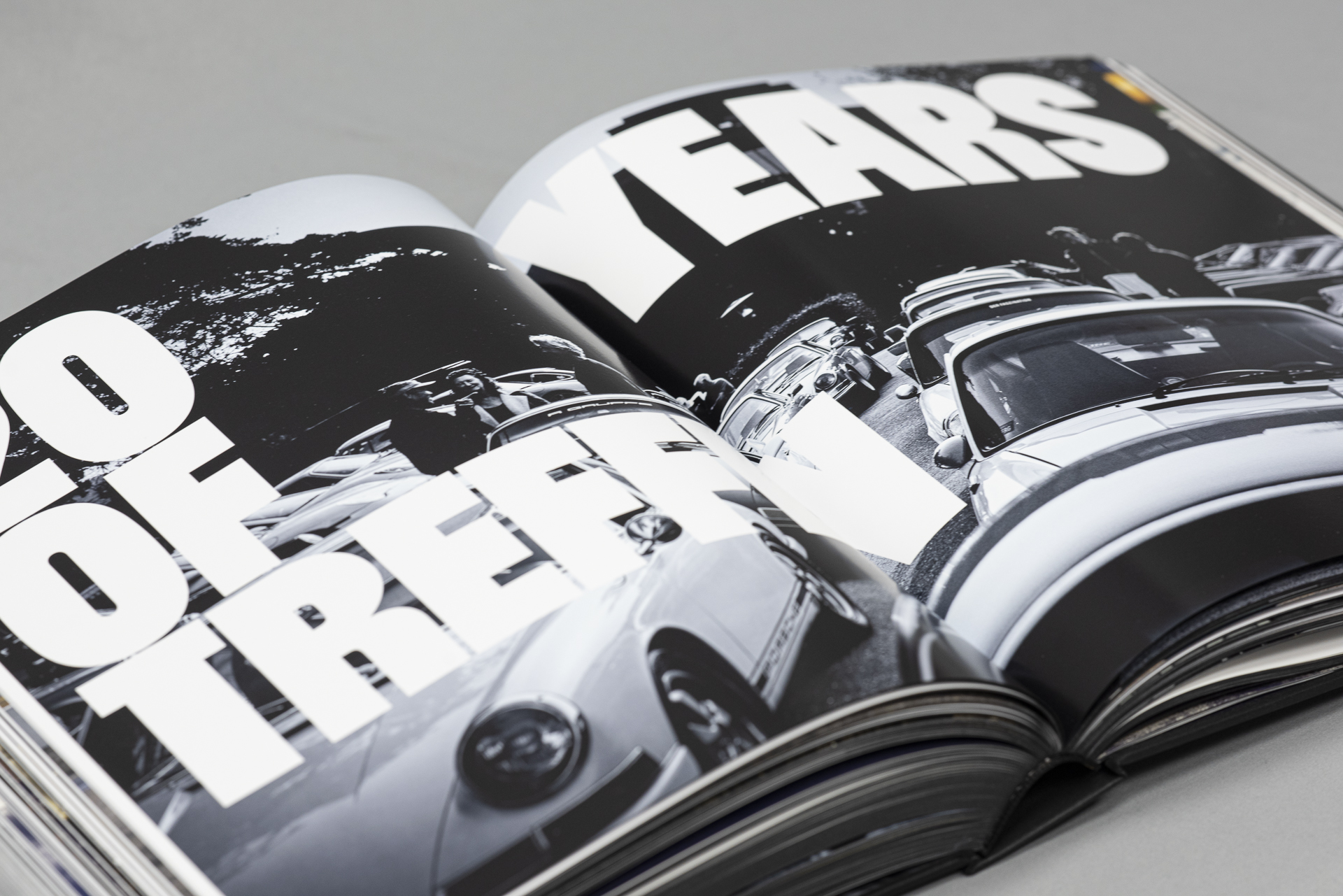 Kapitelaufmacherseite aus dem Buch Frank Kayser: R Gruppe die große Typografie sowie eine schwarz-weiß Aufnahme mehrerer Porsche zeigt.