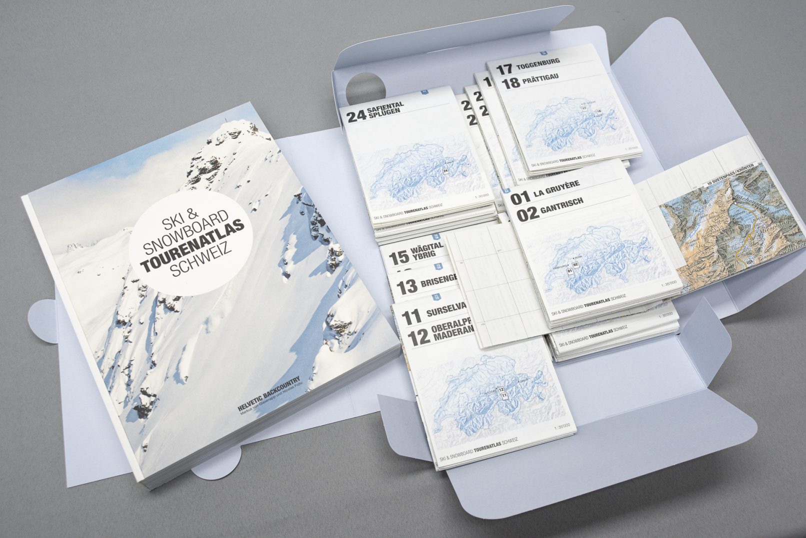 Alle Bestandteile des Ski- und Snowboard Touren Atlas, bestehend aus Buch, Karten und Mappe